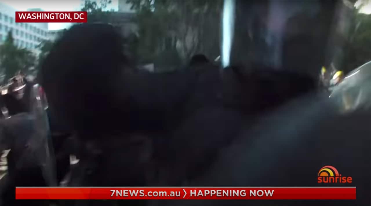 A police officer goes for the camera as the Network Seven crew were broadcasting live.