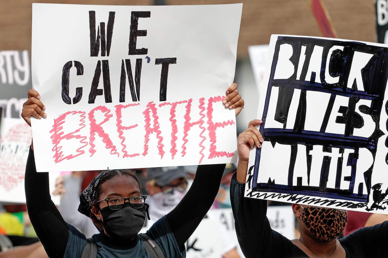 Protesters in Orlando, Florida hold signs during a protest over the death of George Floyd.