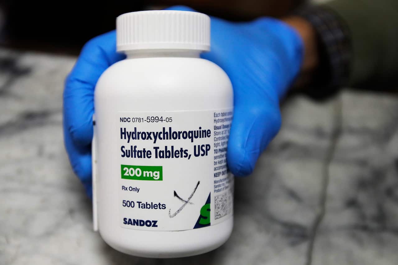 A pharmacist shows a bottle of the drug hydroxychloroquine.