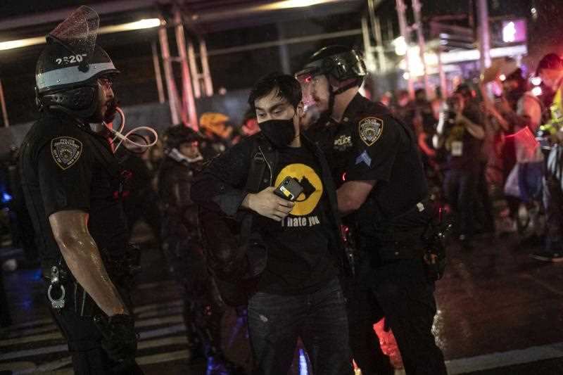 Police arrest protesters who had broken curfew on a marching through the Manhattan borough of New York,