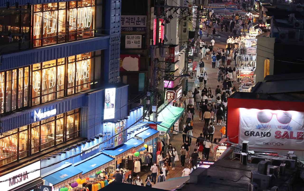 People walk along a road in Hongdae, western Seoul, South Korea.