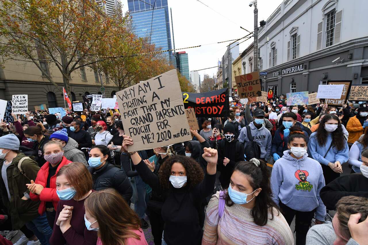Protesters wearing masks protest against Indigenous deaths in custody. 