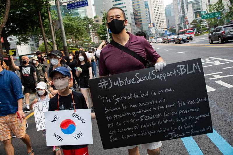 People march as they hold banners during a Black Lives Matter rally in downtown Seoul