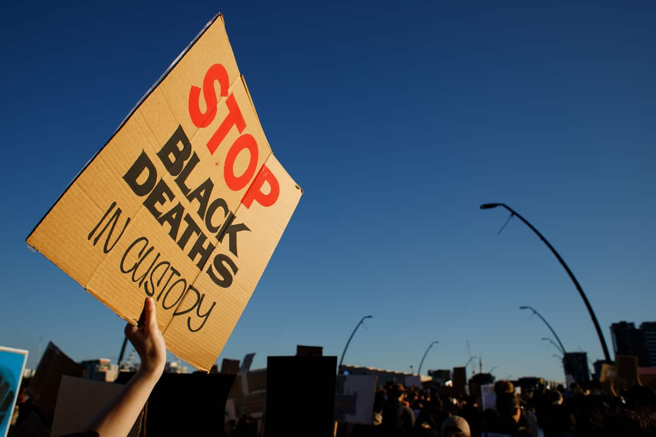 A protesters displays a placard reading "STOP BLACK DEATHS IN custody" during the protest and march over Victoria Bridge. (Photo by Joshua Prieto / SOPA Images/Sipa USA)