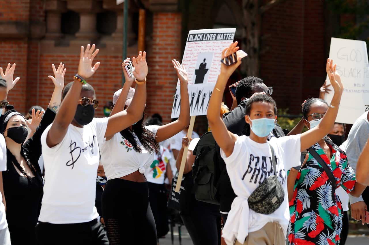 Protesters put their hands in the air as they chant "hands up, don't shoot" during a "pray and protest" rally and march on Sunday.