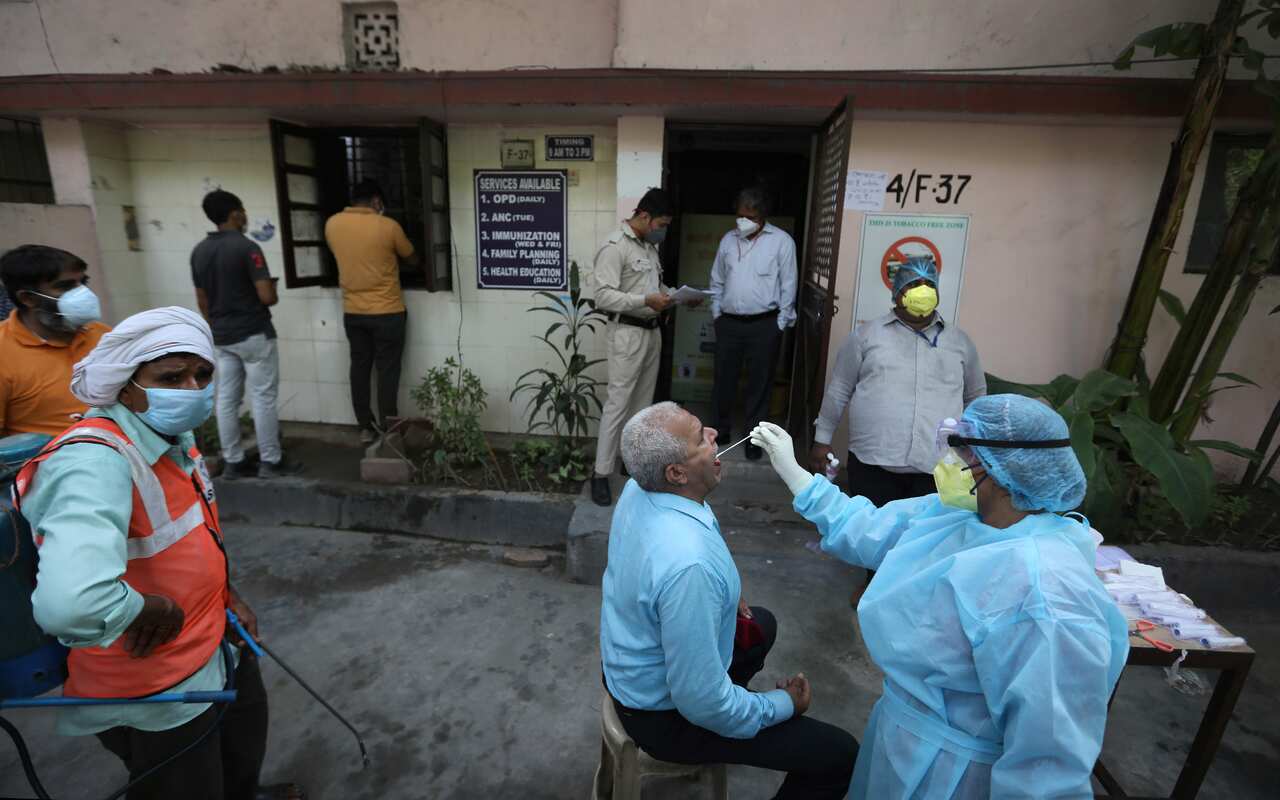 A health worker takes a swab test of an elderly man for COVID 19 in New Delhi, India.