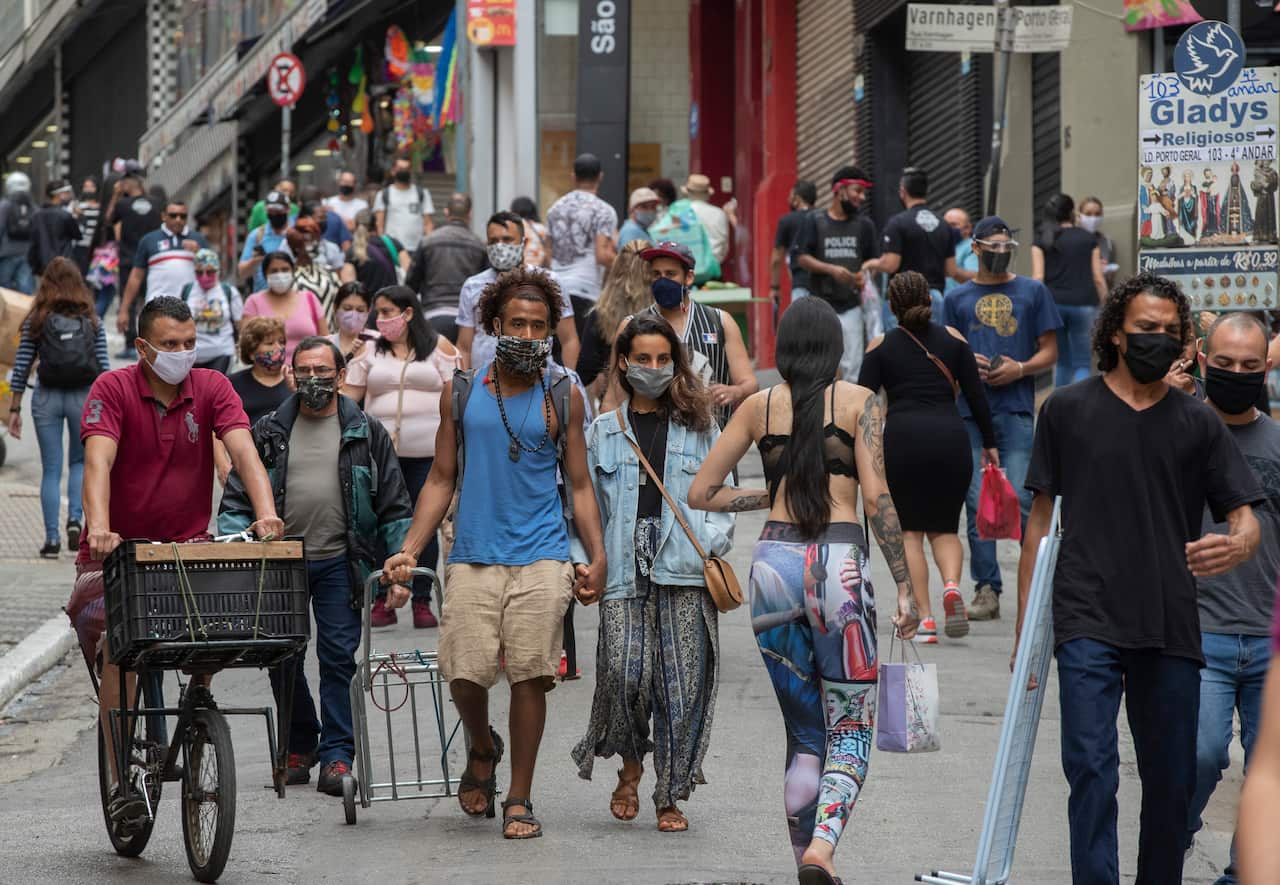 People walk through a downtown shopping district in Sao Paulo, Brazil.