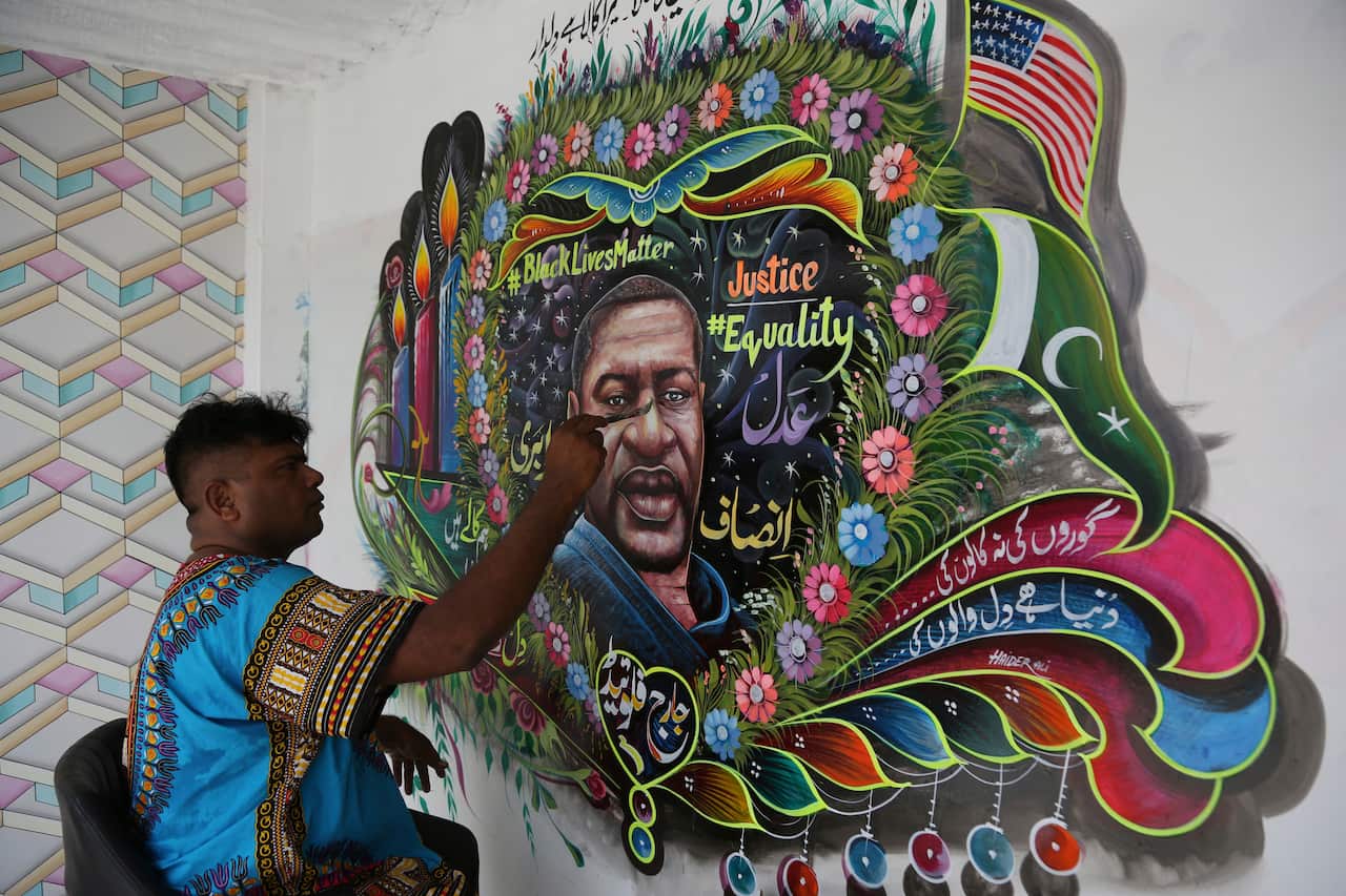 Pakistani truck-art artist Haider Ali paints the portrait of George Floyd on the wall of his home in Karachi, Pakistan.