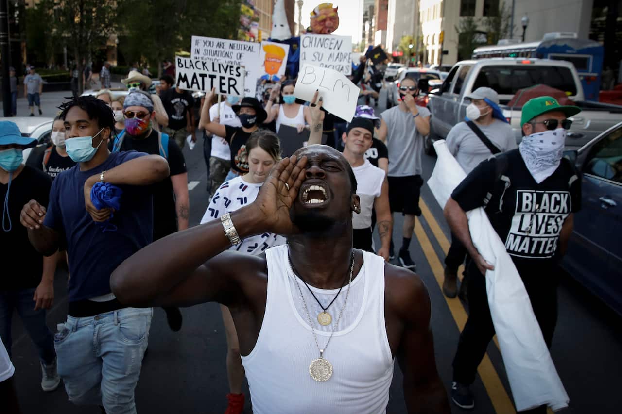 Demonstrators march outside President Donald Trump's campaign rally in Tulsa, Oklahoma.