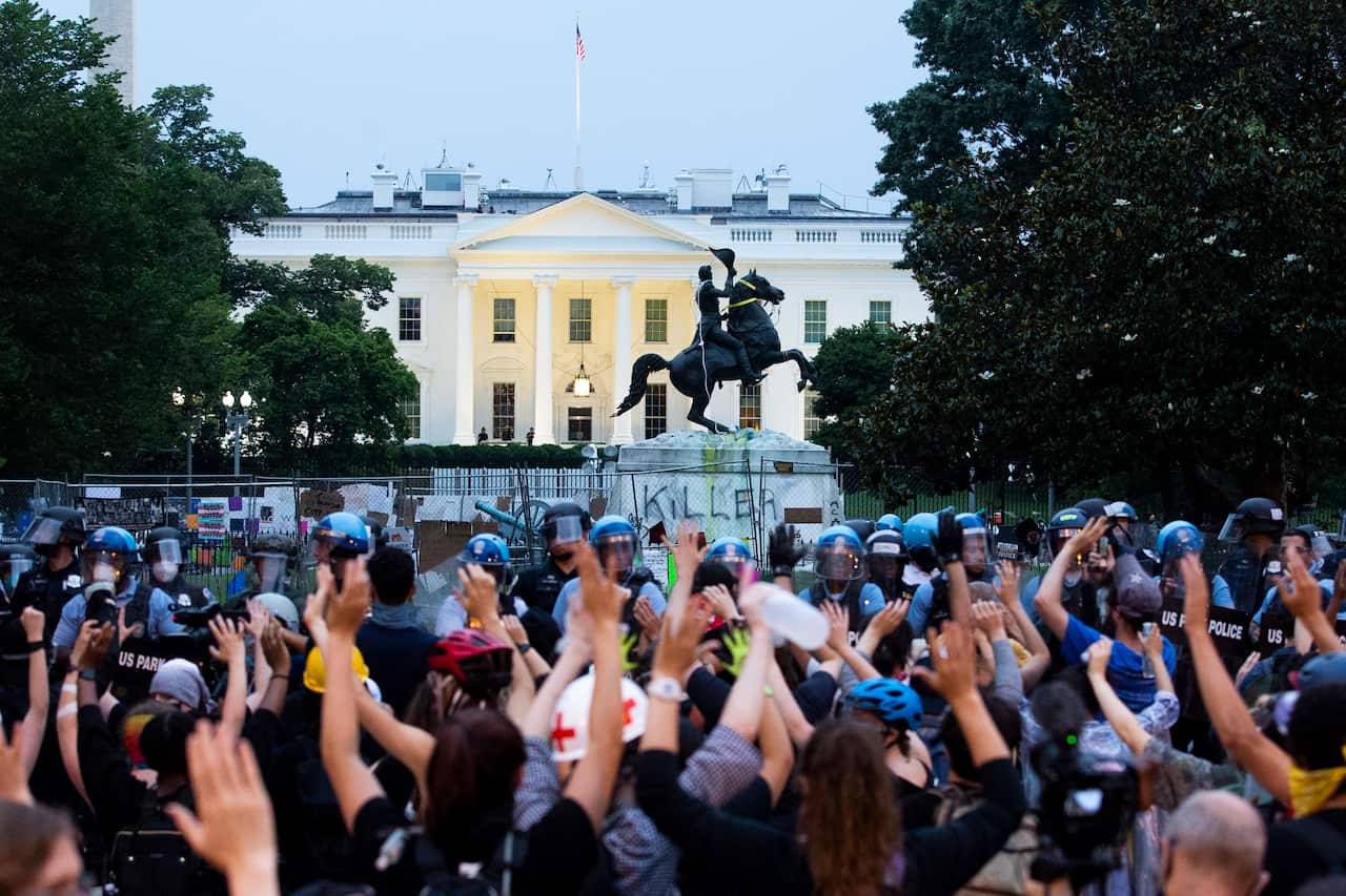 Protesters put their hands in the air after attempting to pull down the Andrew Jackson statue.