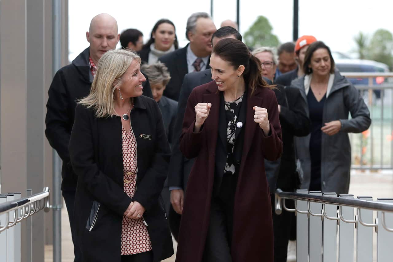 New Zealand Prime Minister Jacinda Ardern walks with principal Rose McInerney (L) at the opening of a school in Christchurch.