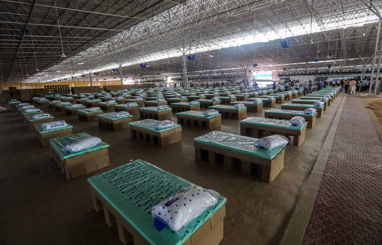 Indian volunteers set up beds made of cardboard inside a COVID care facility that can accommodate around ten thousand patients in New Delhi, India.