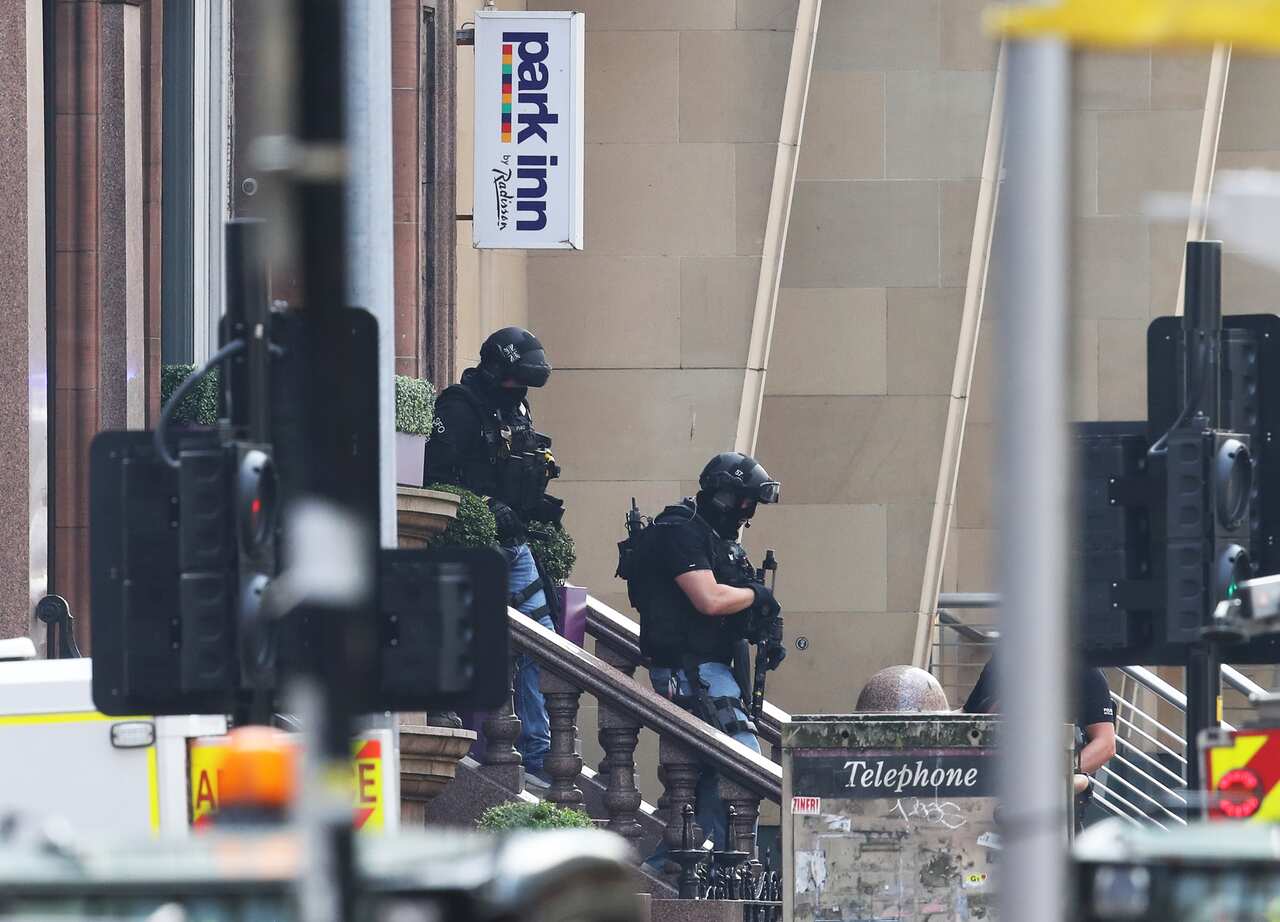 Armed police officers leave the Park Inn hotel in West George Street, Glasgow, where a man has been shot by an armed officer.