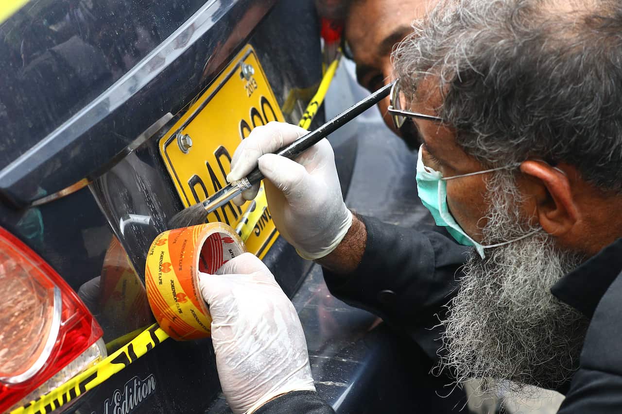 Pakistani security officials inspect the scene of an attack by banned militants outfit Baloch Liberation Army at the Pakistan Stock Exchange in Karachi.