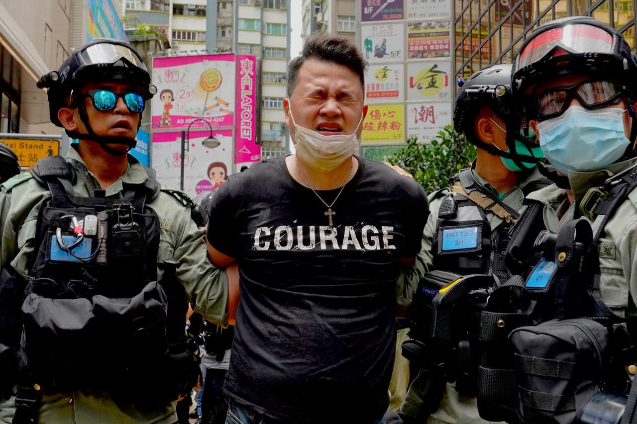 Police detain a protester after using pepper spray during a protest in Causeway Bay before the annual handover march in Hong Kong, Wednesday, July. 1, 2020