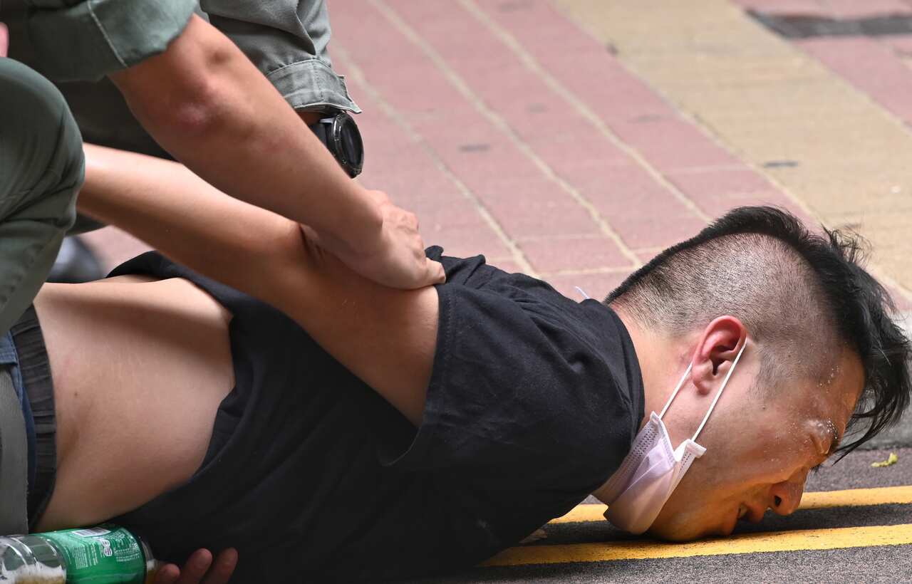 Police officers detain a protester after he was pepper sprayed 