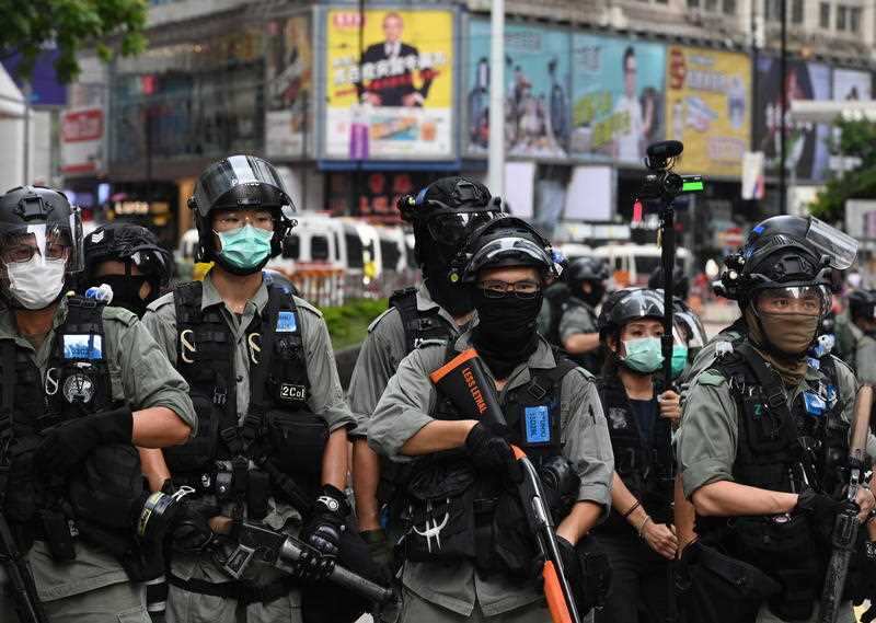 Riot police guard a road in Hong Kong