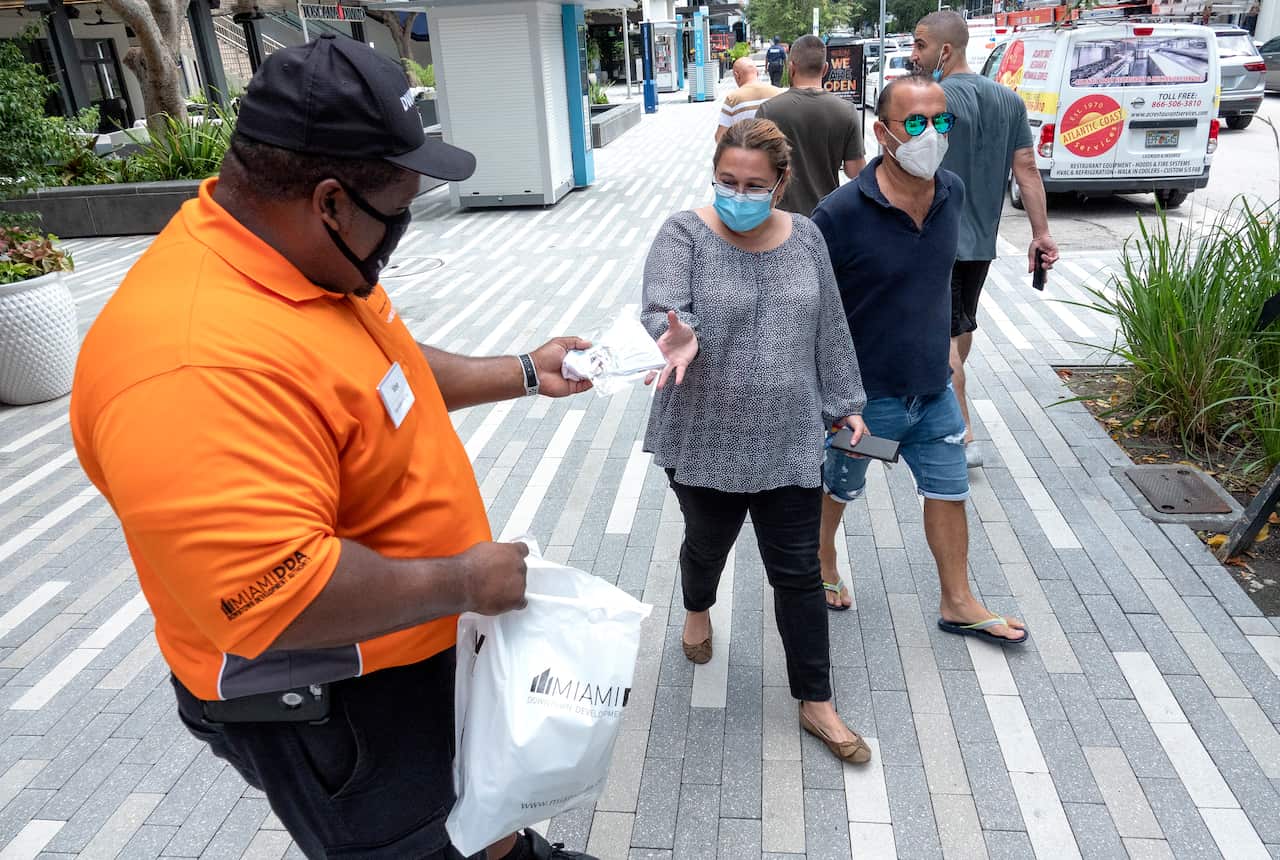 An health worker distributes free face masks in Downtown Miami, Florida.