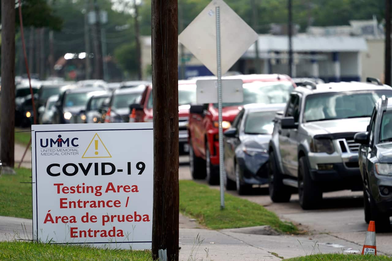 People wait inside their vehicles in line at a COVID-19 testing site in Houston, Texas.