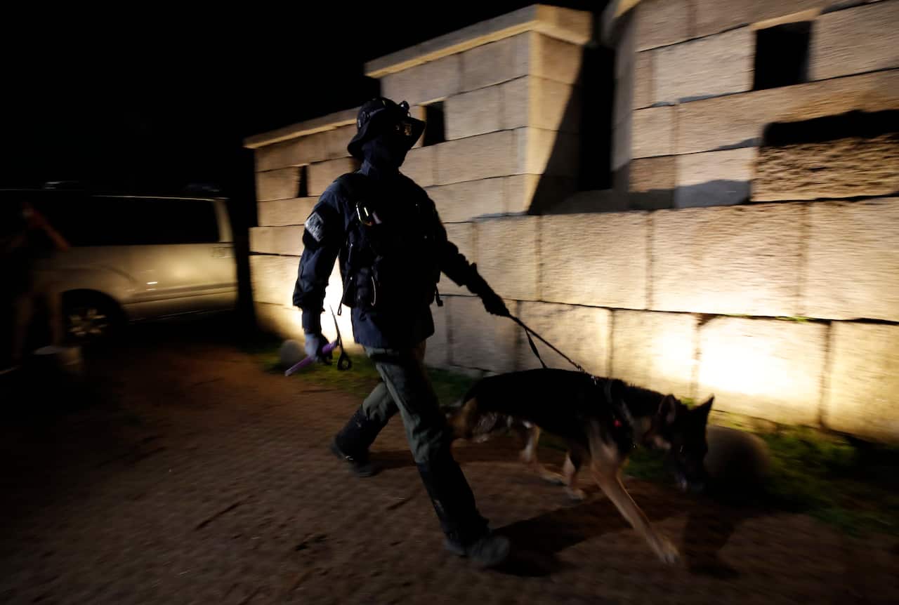 A South Korean police officer with a dog search for missing Seoul Mayor Park Won-soon in Seoul, South Korea, Thursday, July 9, 2020. (AP Photo/Lee Jin-man)