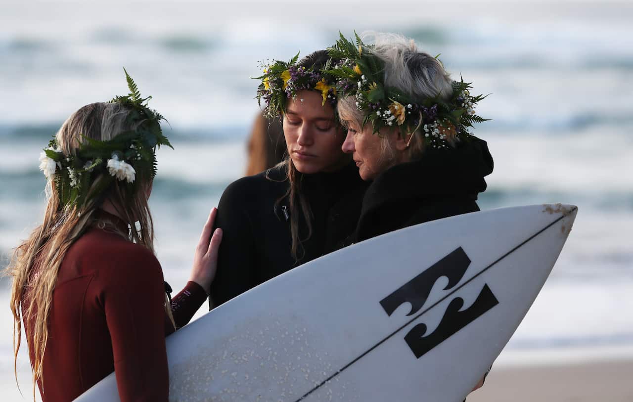Friends console each other at Palm Beach, Gold Coast where Alex Pullin drowned on July 8.