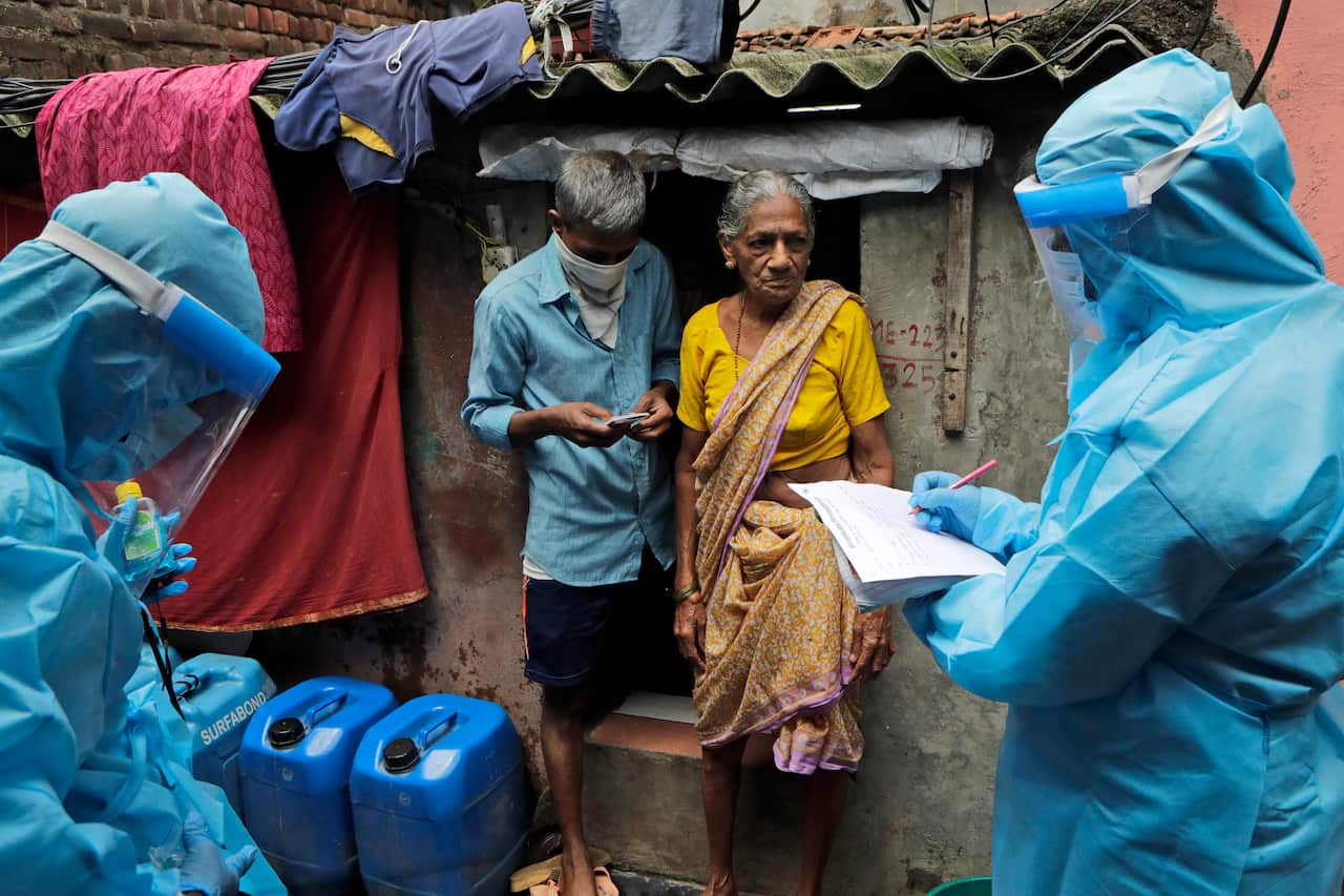 Health workers screen people for COVID-19 symptoms at Devnar slum in Mumbai, India.