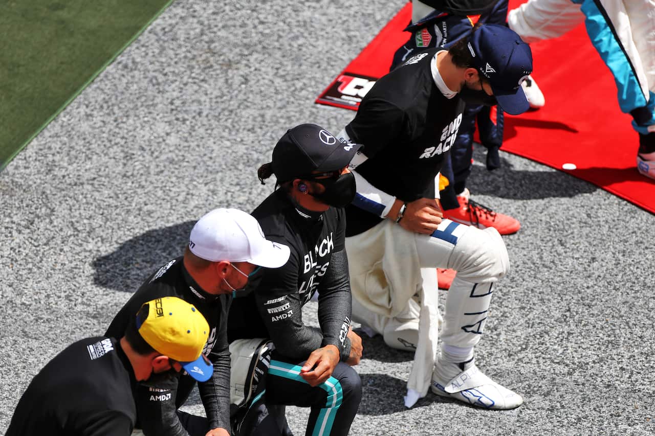 Lewis Hamilton takes a knee with team mate Valtteri Bottas on the grid.