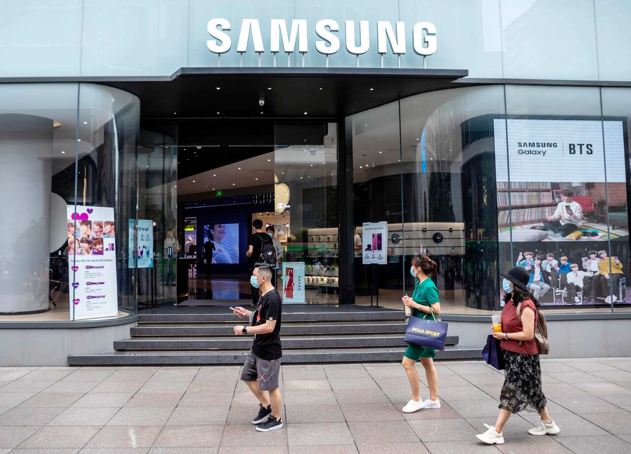People walk past a Samsung store in Shanghai, China.