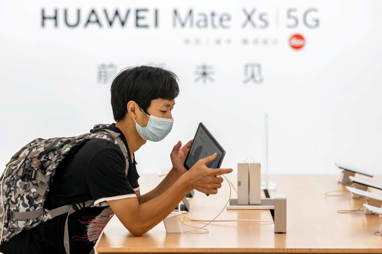 People wearing face masks visit Huawei's newest flagship store in Shanghai.