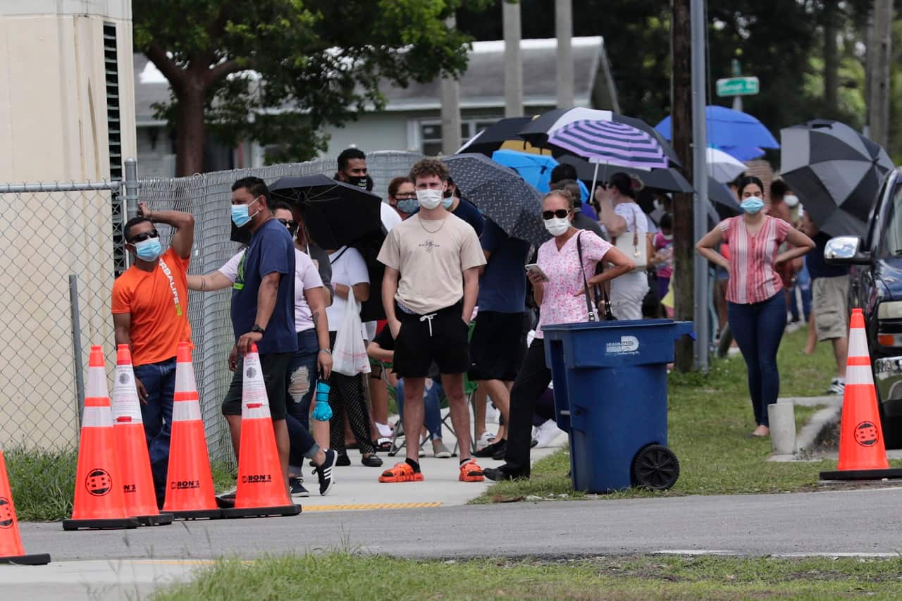 People wait in line outside of a COVID-19 testing site in Florida.