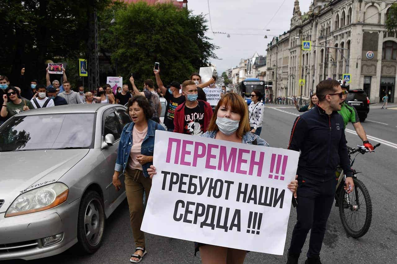 A woman carries a placard reading "Our Hearts Call for Changes".