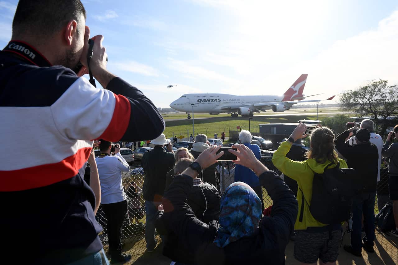Spectators and aviation enthusiasts watch on from Sheps Mound as the last remaining Qantas 747-400 aircraft is seen departing Sydney