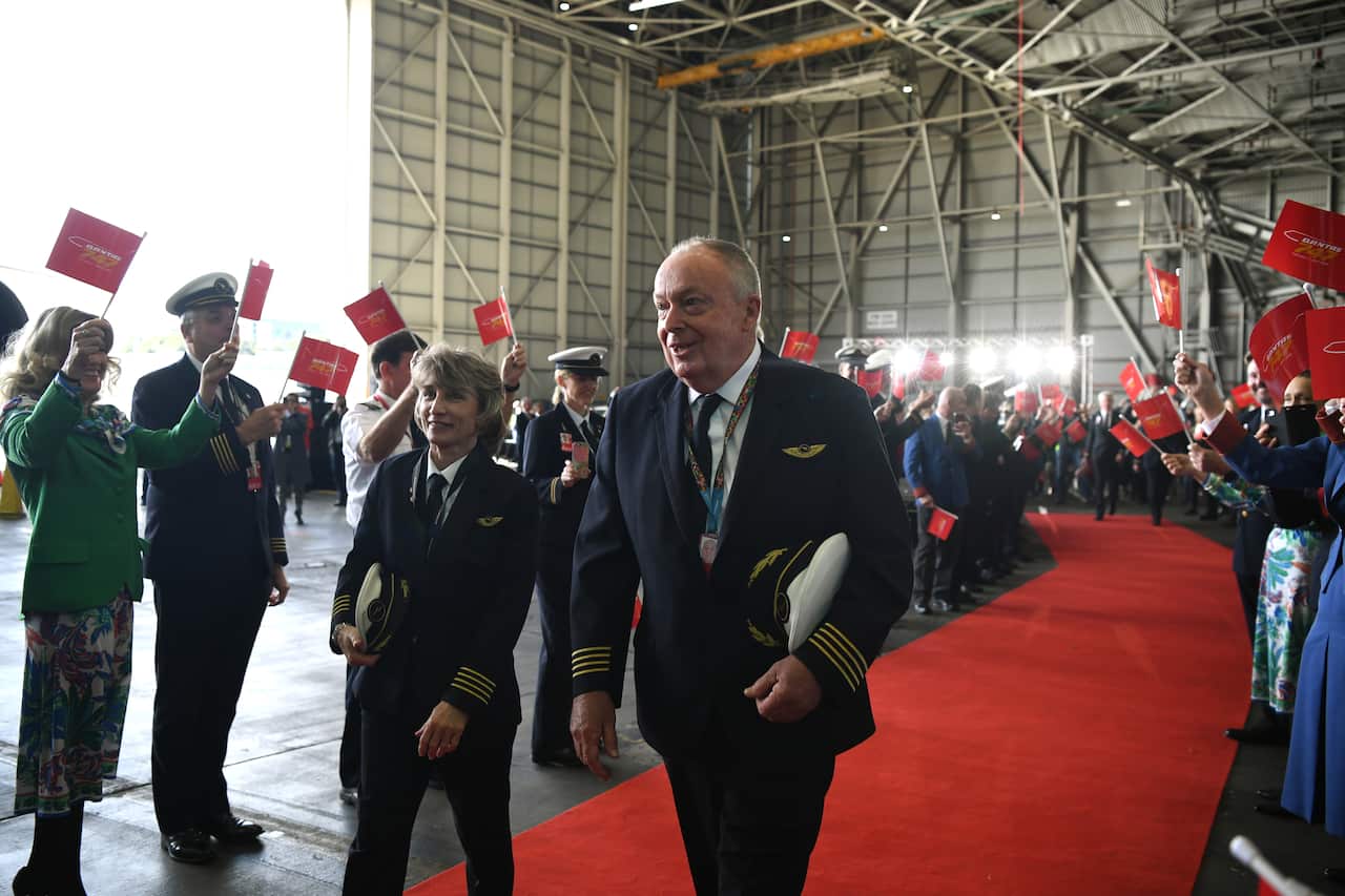 Captains Sharelle Quinn (left) and Ewen Cameron receive a guard of honour as they board Qantas Airways flight QF7474 