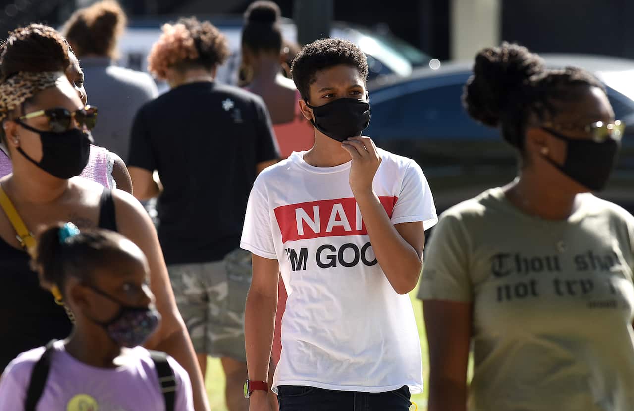 A family wearing face masks as a preventive measure during a walk at Orlando's Lake Eola Park in Florida.