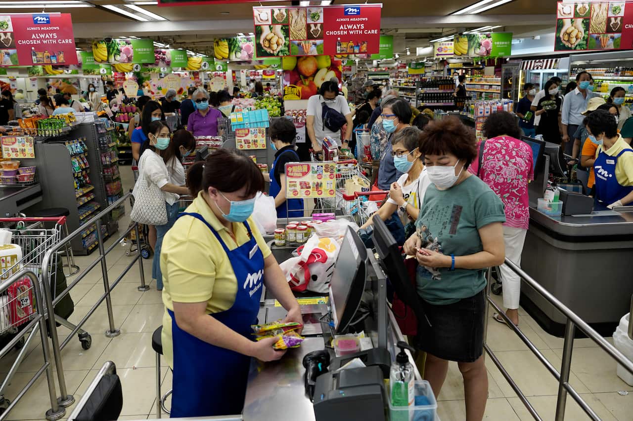 People wearing face masks to protect against the new coronavirus as they shop at a supermarket in Hong Kong
