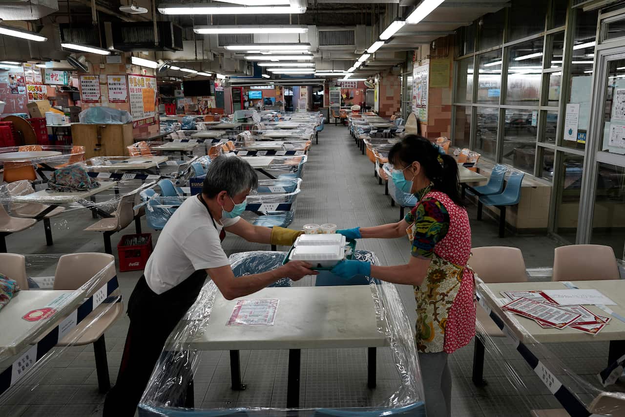 Restaurant staff prepare take aways at a Chinese food court in Hong Kong. Dining-in at restaurants has been banned and mask wearing made mandatory.