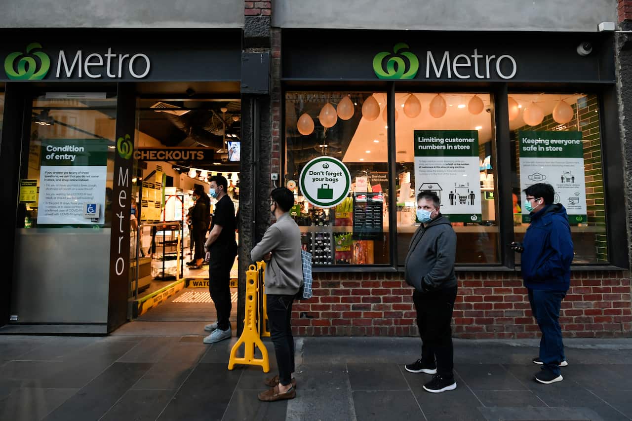 People line up to enter a supermarket hours in Melbourne.