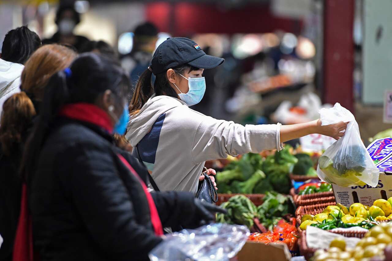 People shop at Queen Victoria Market hours before a citywide curfew is introduced in Melbourne.