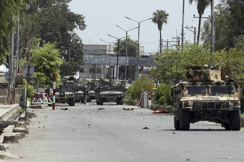 Afghan security personnel gather in front of a prison after an attack in the city of Jalalabad, east of Kabul, Afghanistan, Monday, Aug. 3, 2020.