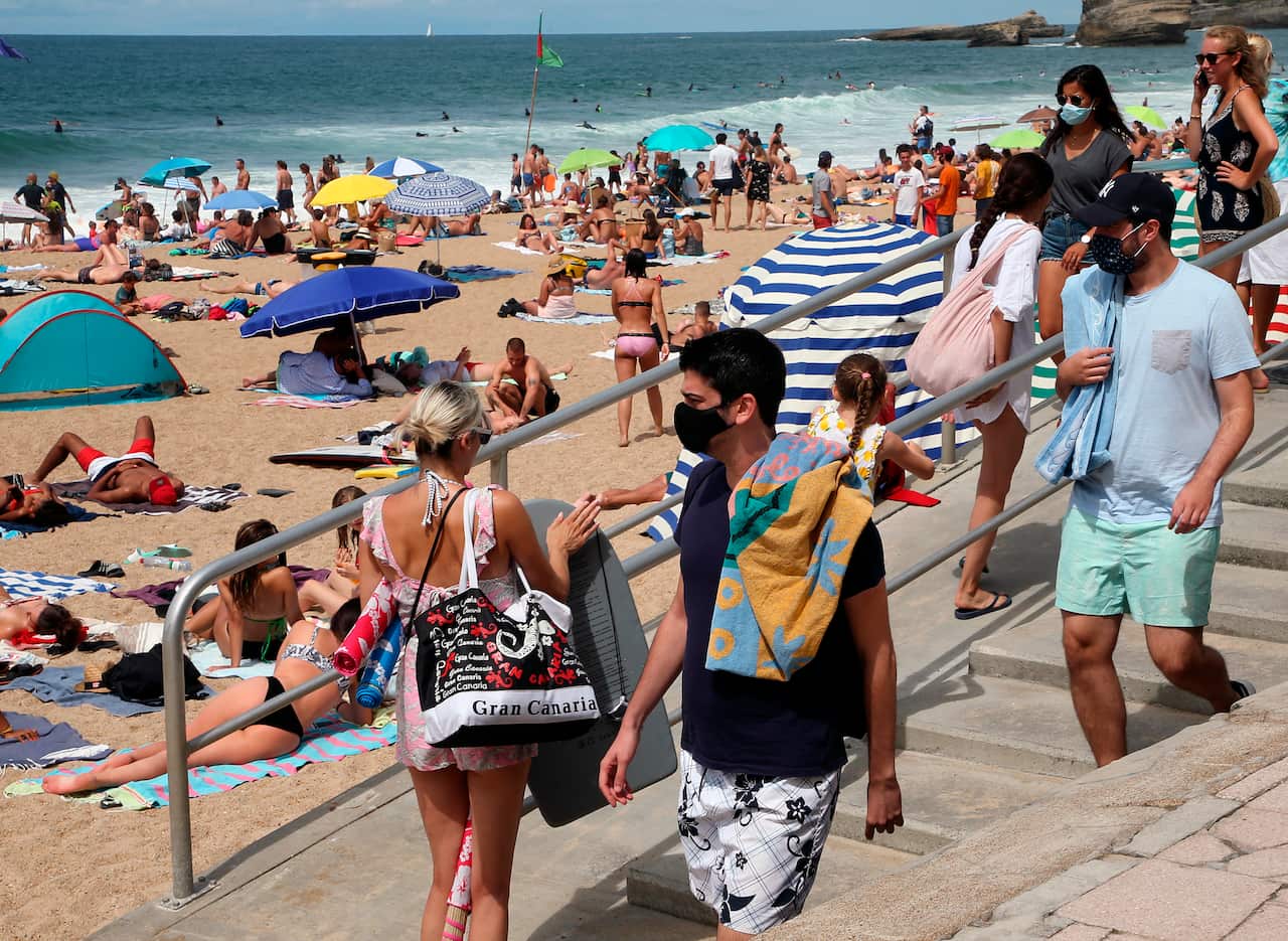 People wearing face masks at the beach in Biarritz, southwestern France.