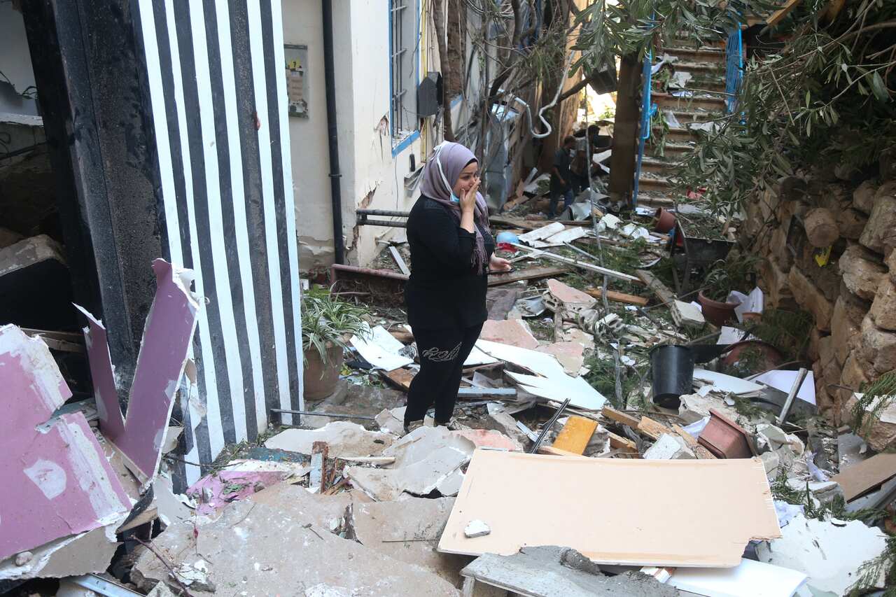 A Lebanese woman reacts to the destruction around her, one day after the explosion at the Beirut Port.