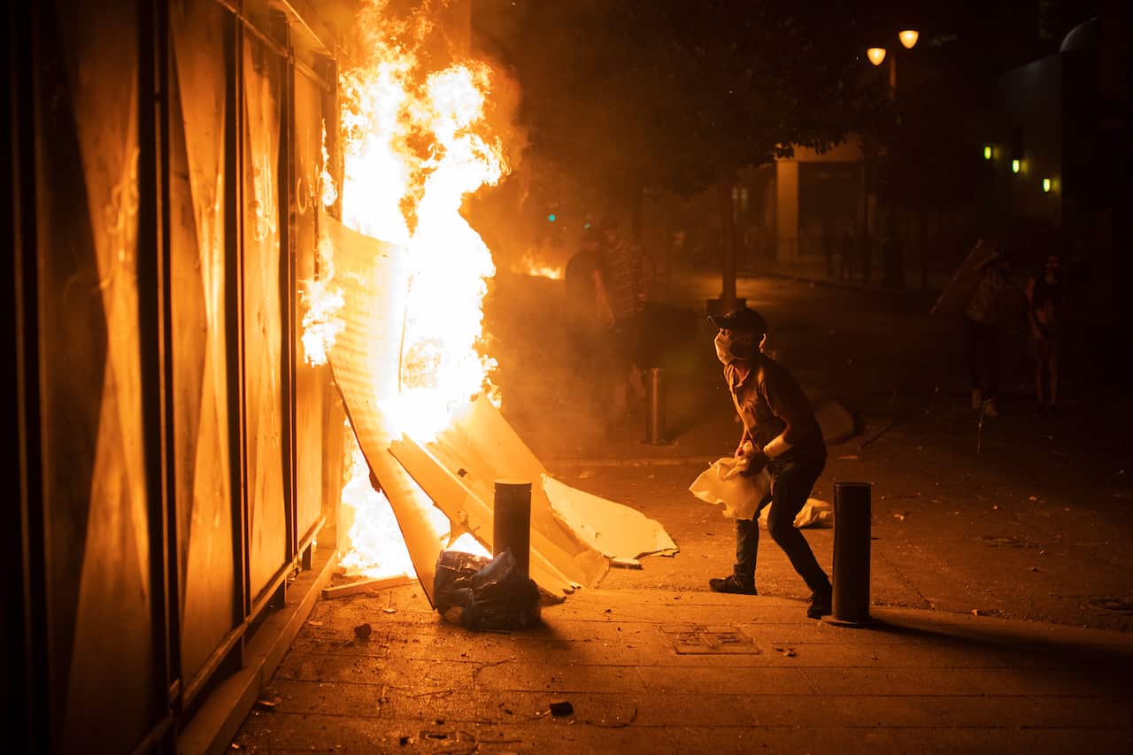 Anti-government protesters throw stones and clash with the riot police, during a protest against the political elites who have ruled the country for decades, in Beirut