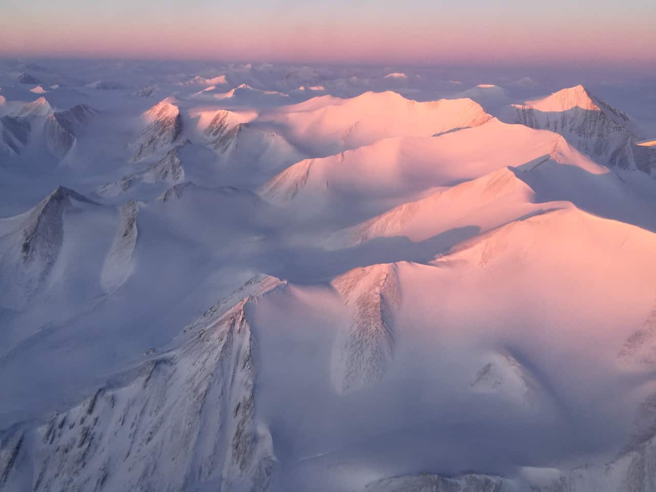 Ellesmere Island mountain tops bathed in light as the sun began to peak over the horizon during Operation IceBridge's first flight of its 2017 Arctic campaign. 