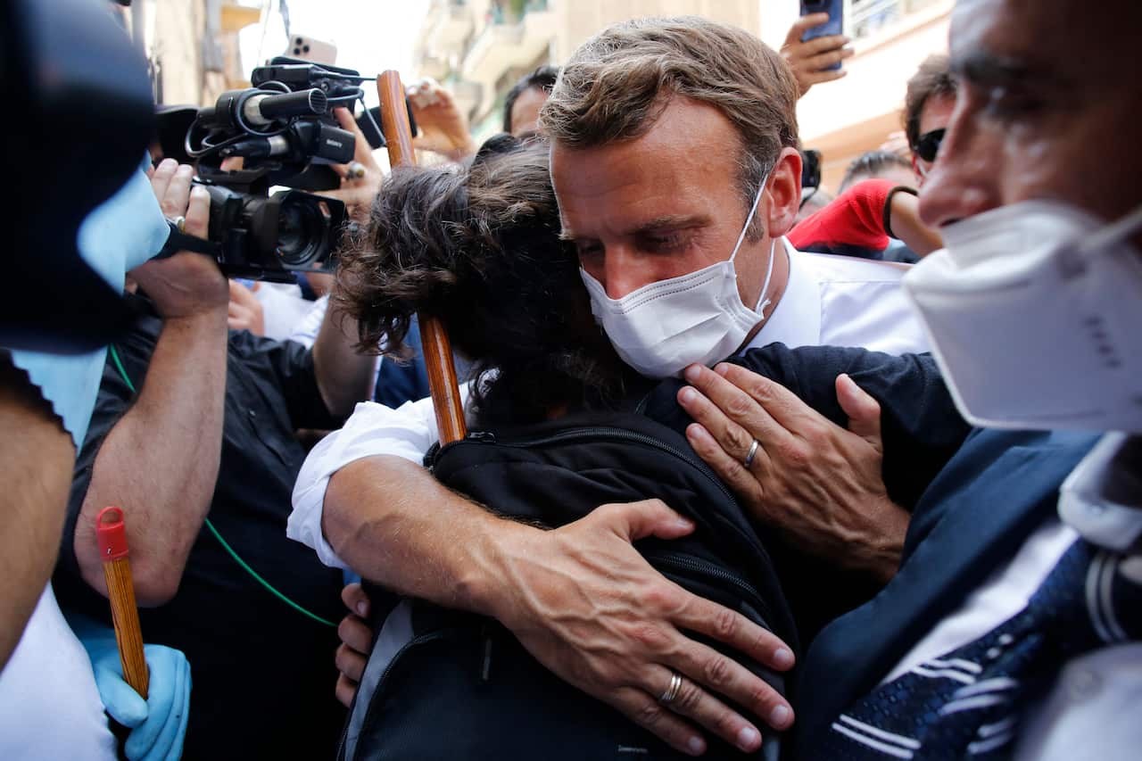 French President Emmanuel Macron hugs a resident as he visits a devastated street of Beirut, Lebanon.