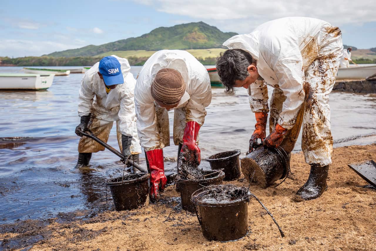 Local volunteers clean up oil washing up on the beach from the MV Wakashio, a Japanese owned Panama-flagged bulk carrier ship that is leaking oil of Mauritius.