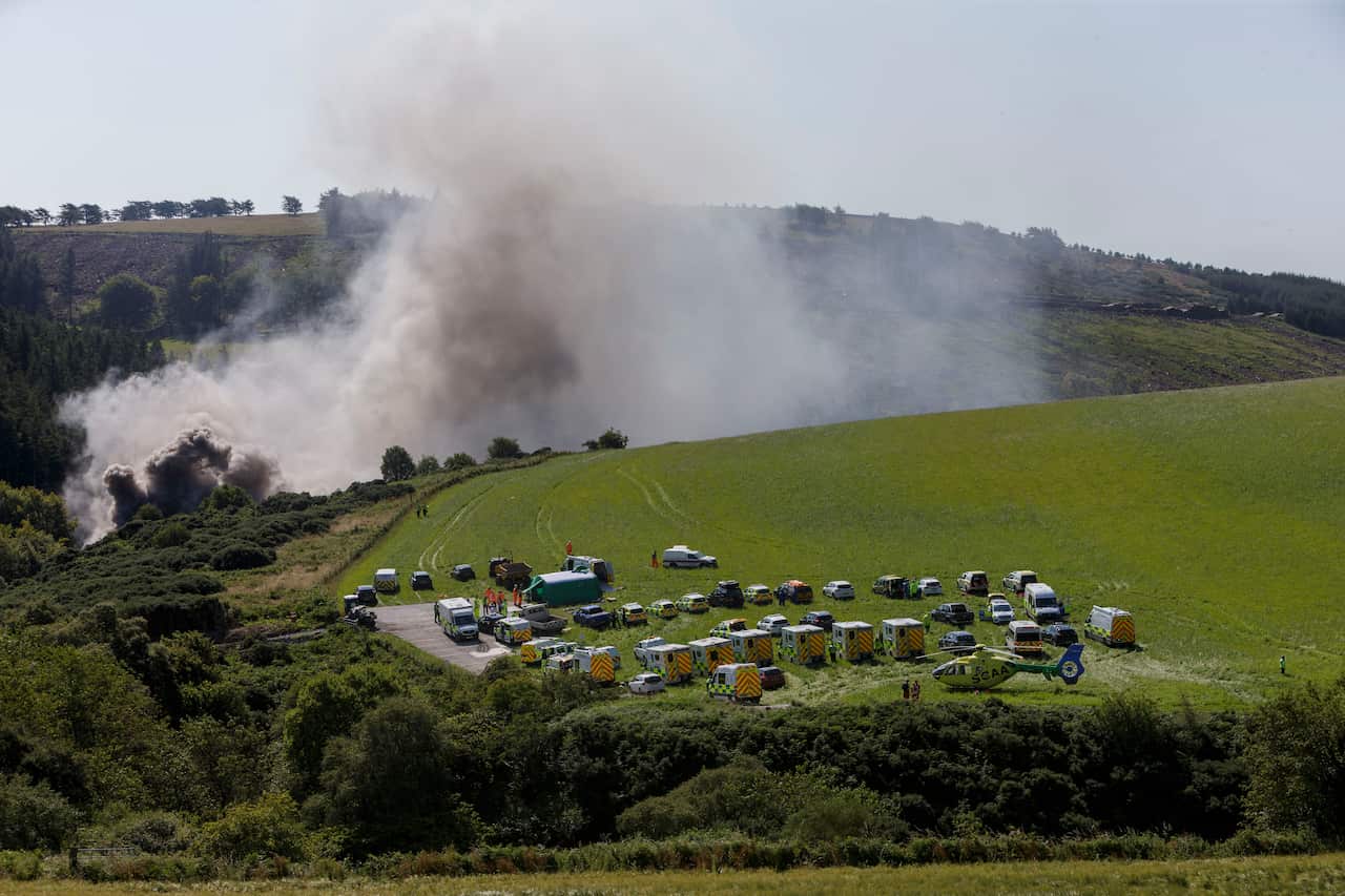 Emergency services attend the scene of a derailed train in Stonehaven, Scotland.