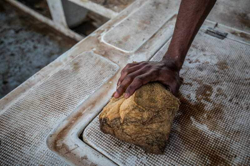 A volunteer fishermen cleans oil off his boat
