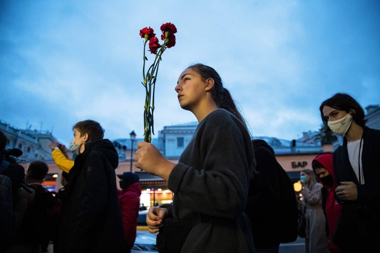 A woman holds flowers as people, some of them ethnic Belarusians, gather to support Belarusian opposition in Moscow, Russia, on 13 August.
