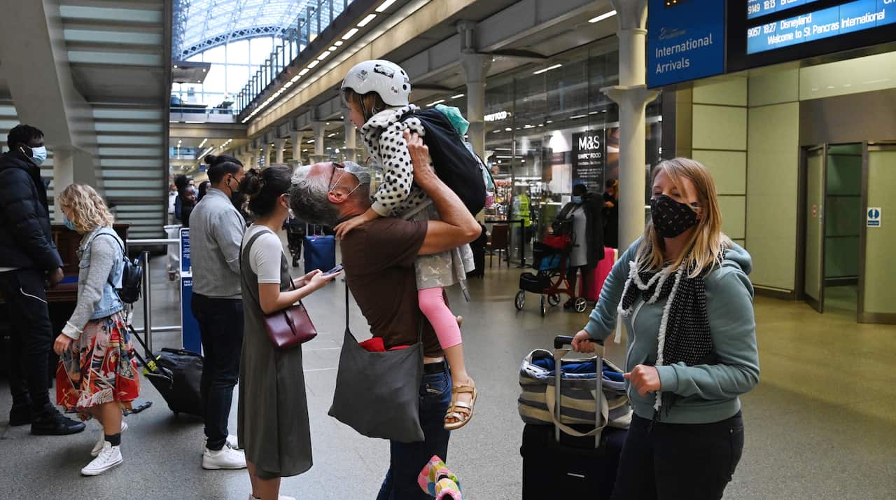 A man greets his daughter after arriving in London on a Eurostar train from Paris on 14 August.