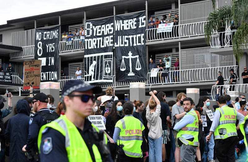 Police and protesters are seen during a rally in support of asylum seekers detained at the Kangaroo Point Central Hotel in Brisbane, Saturday, August 15, 2020.